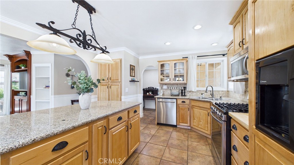 21104 Rosedell Drive Saugus, CA 91350 - Photo 11 of 33 Beautiful kitchen with center island, granite countertops, travertine backsplash and matching refrigerator panels