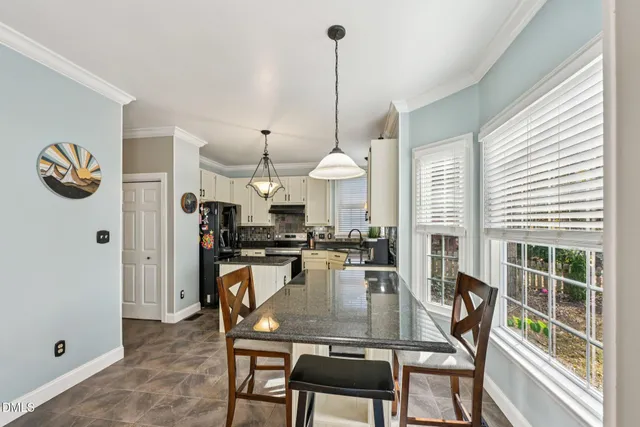 a kitchen with kitchen island a dining table chairs and a wooden floor