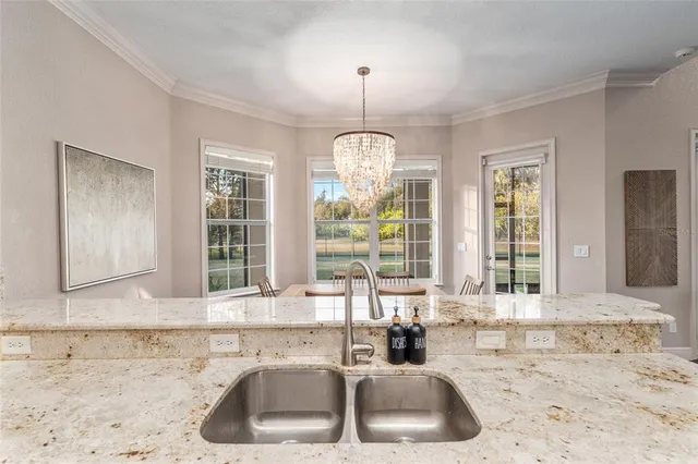 a bedroom with a bed a flat screen tv and a chandelier