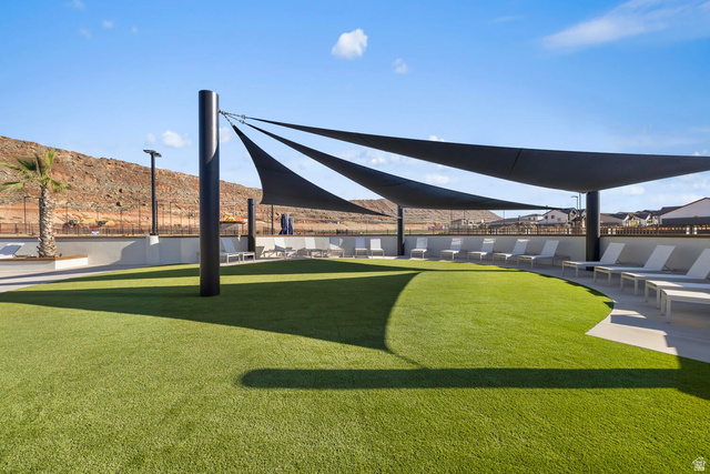 2133 Wolverine Way, Unit 2440 Washington, UT 84780 - Photo 31 of 39 Expansive amenity lawn with artificial turf, multiple lounge chairs, and shade sails