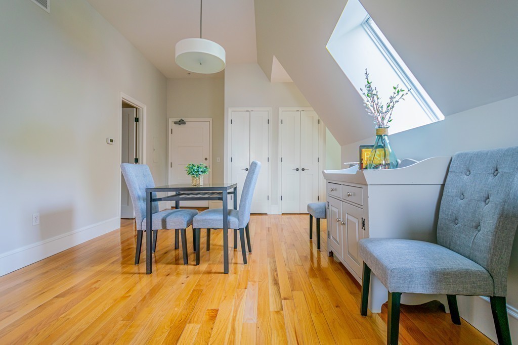 33 Forest Street, Unit 413 Lexington, MA 02421 - Photo 15 of 29 a view of a dining room with furniture and wooden floor