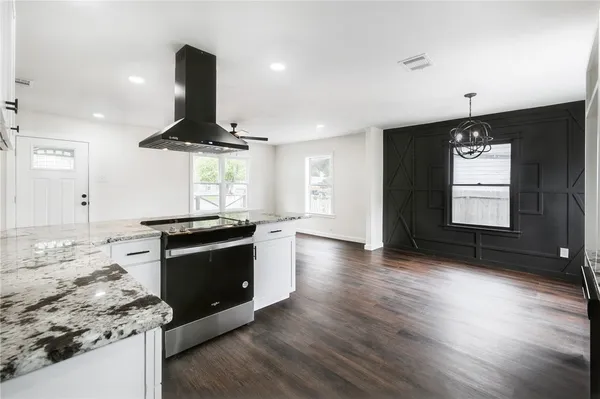 a kitchen with stainless steel appliances granite countertop a stove and a wooden floors