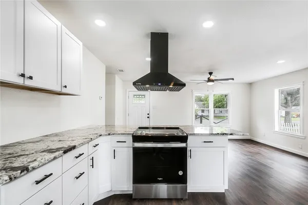 a kitchen with stainless steel appliances granite countertop a stove a sink and a microwave