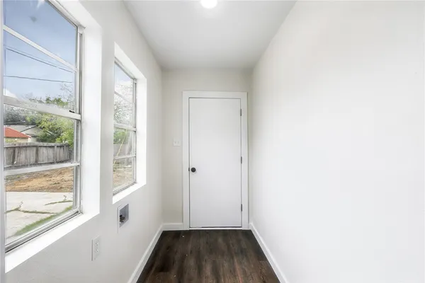 a view of a room that has wooden floor and a window