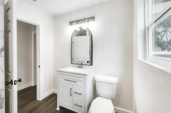 a bathroom with a toilet a sink and mirror