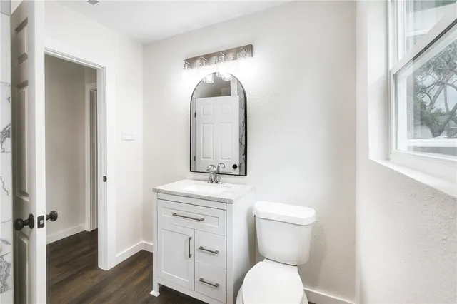 a bathroom with a toilet a sink and mirror
