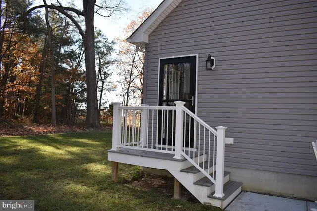 a view of a chair and table in backyard of the house