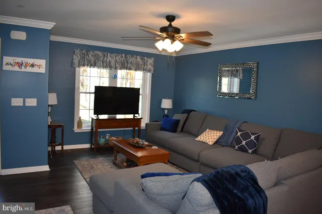 a living room with furniture a flat screen tv and a chandelier
