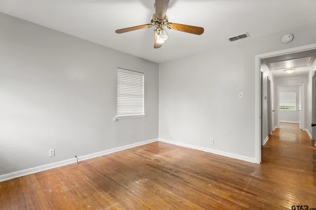 wooden floor in an empty room with a window