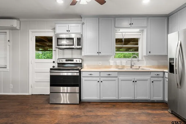 a kitchen with stainless steel appliances a refrigerator sink and stove