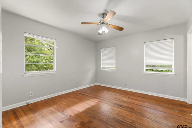 a view of a room with wooden floor and chandelier fan