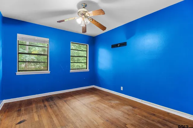 a view of empty room with window and ceiling fan