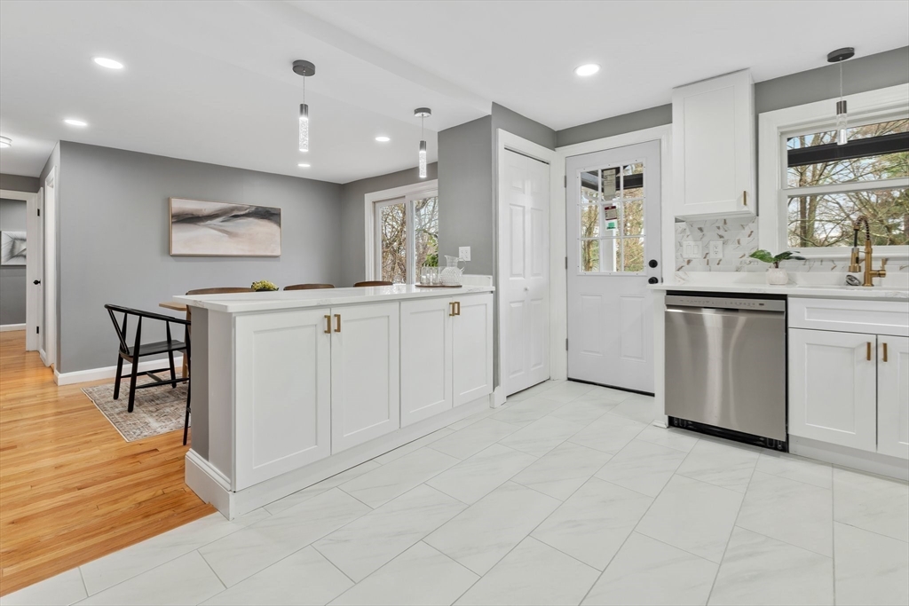 25 Parker Street Newton, MA 02459 - Photo 13 of 38 a kitchen with white cabinets appliances and a dining table