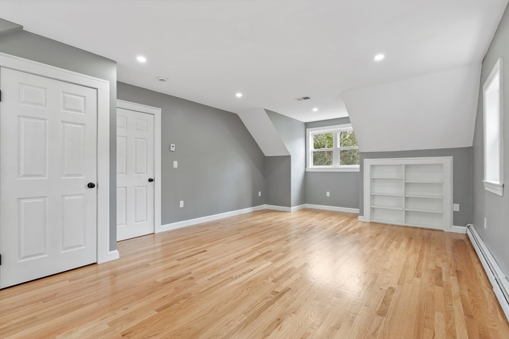 25 Parker Street Newton, MA 02459 - Photo 27 of 38 a view of empty room with wooden floor and fireplace