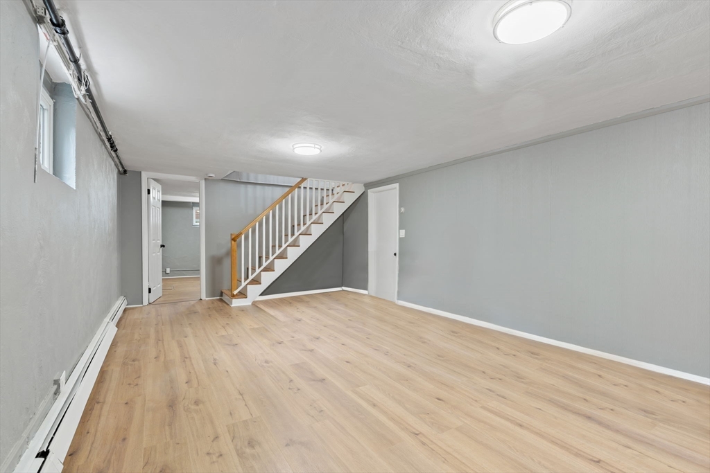 25 Parker Street Newton, MA 02459 - Photo 32 of 38 a view of an empty room with wooden floor and stairs