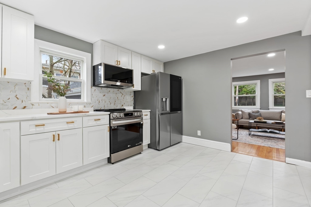 25 Parker Street Newton, MA 02459 - Photo 9 of 38 a kitchen with stainless steel appliances kitchen island granite countertop a stove a sink and a refrigerator