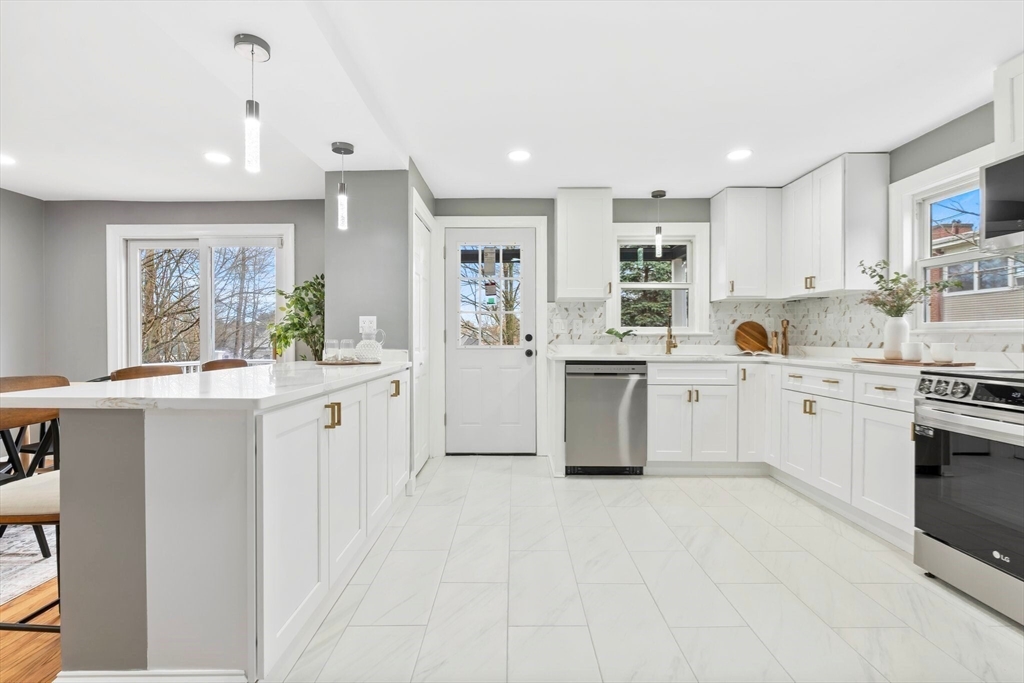 25 Parker Street Newton, MA 02459 - Photo 10 of 38 a kitchen with white cabinets and white appliances