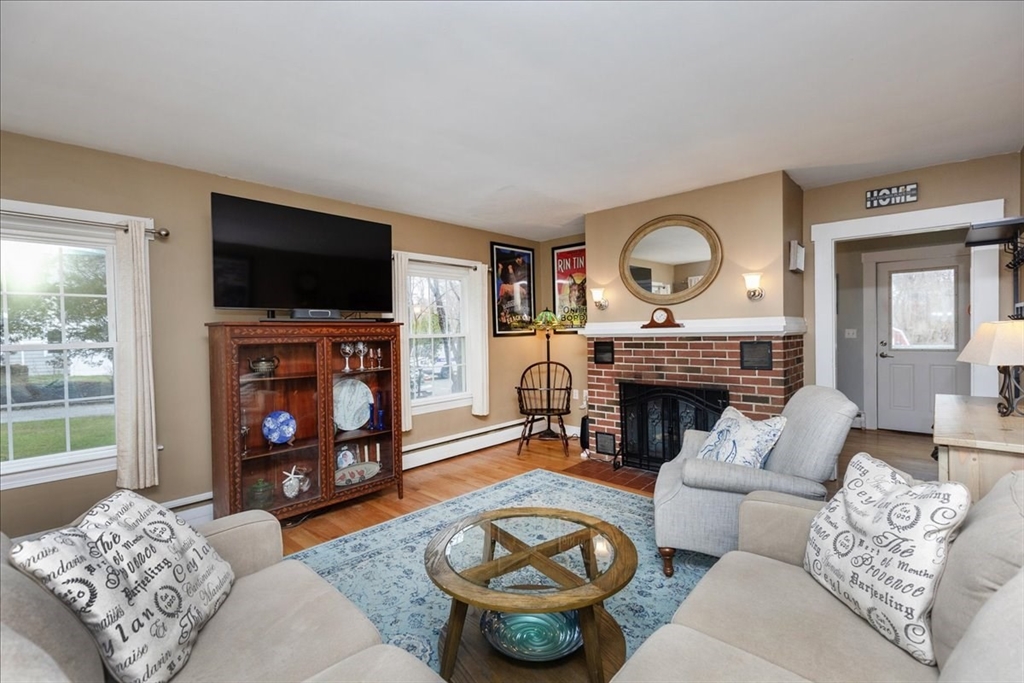 61 Beach Road Salisbury, MA 01952 - Photo 4 of 27 a living room with furniture a flat screen tv and a fireplace