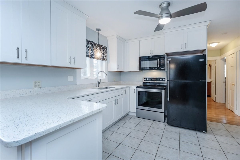 61 Beach Road Salisbury, MA 01952 - Photo 7 of 27 a kitchen with a refrigerator sink and cabinets
