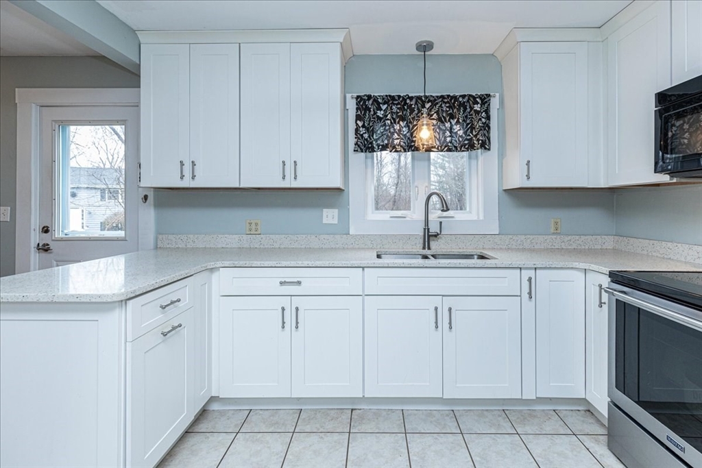 61 Beach Road Salisbury, MA 01952 - Photo 8 of 27 a kitchen with white cabinets appliances and a sink
