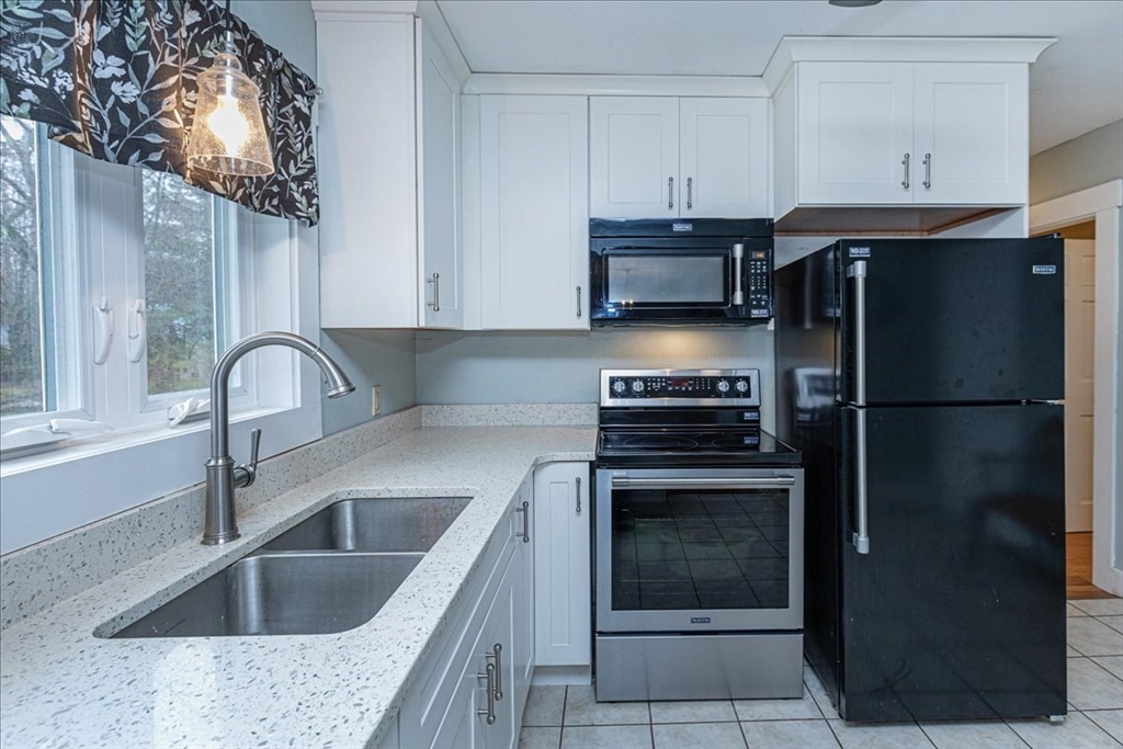 61 Beach Road Salisbury, MA 01952 - Photo 10 of 27 a kitchen with a sink stove and refrigerator