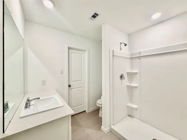 a bathroom with a sink toilet and shower
