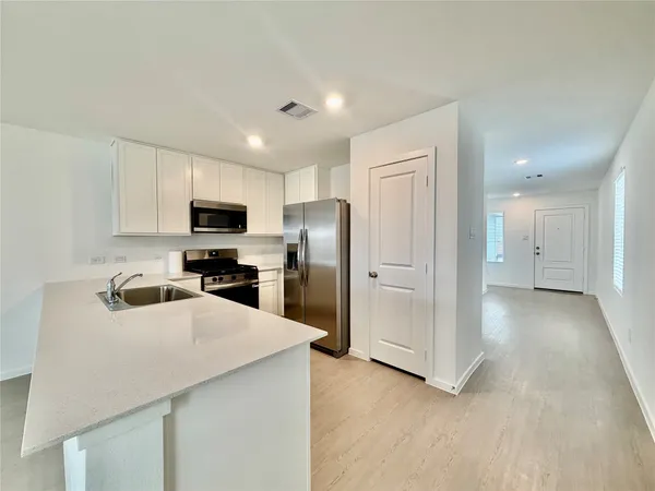 a kitchen with a refrigerator a microwave and sink