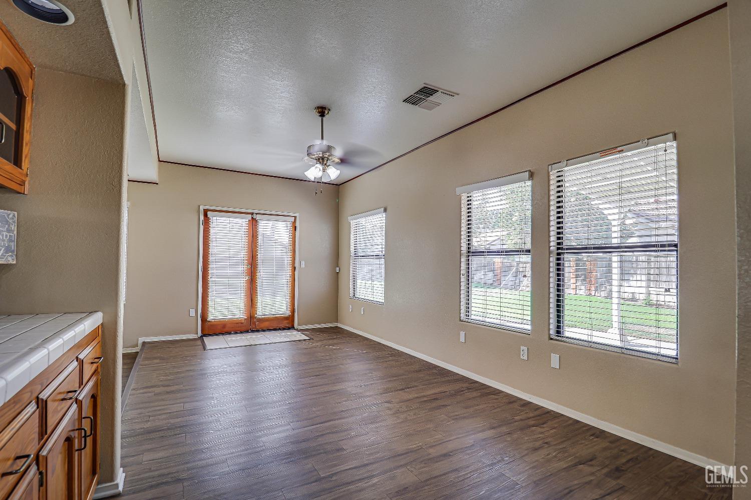 Undisclosed Address Bakersfield, CA 93311 - Photo 19 of 51 a view of an empty room with wooden floor and a window