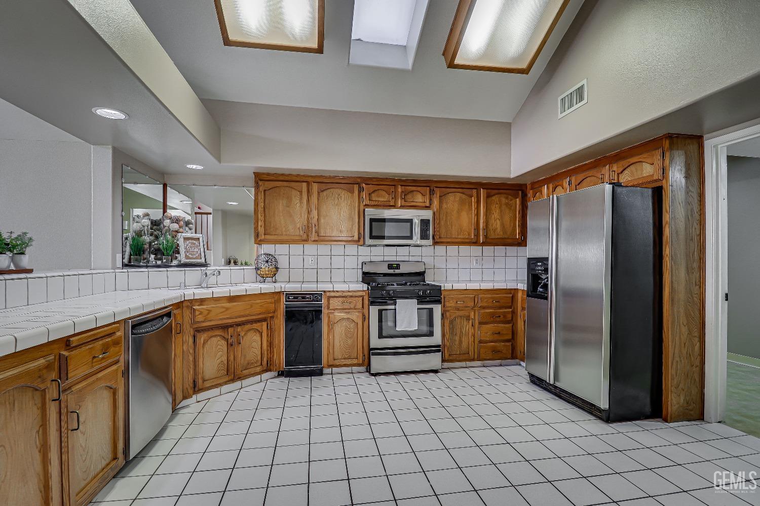 Undisclosed Address Bakersfield, CA 93311 - Photo 24 of 51 a large kitchen with stainless steel appliances granite countertop a refrigerator and a stove top oven