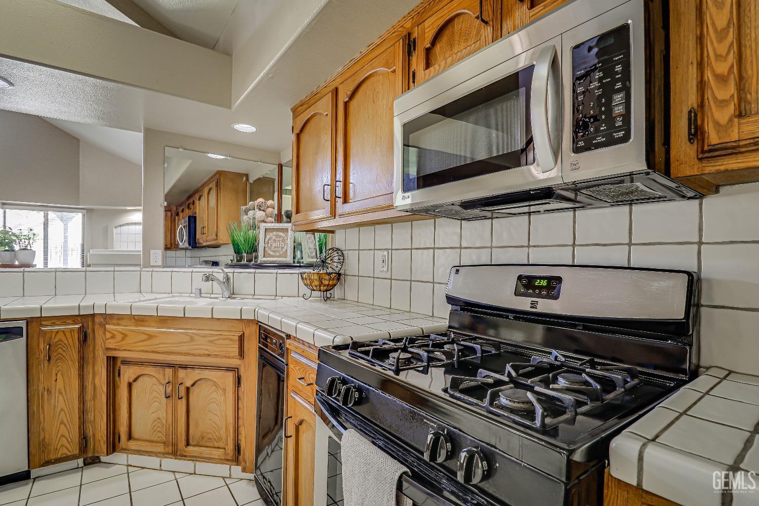 Undisclosed Address Bakersfield, CA 93311 - Photo 26 of 51 a kitchen with stainless steel appliances granite countertop a stove and a microwave