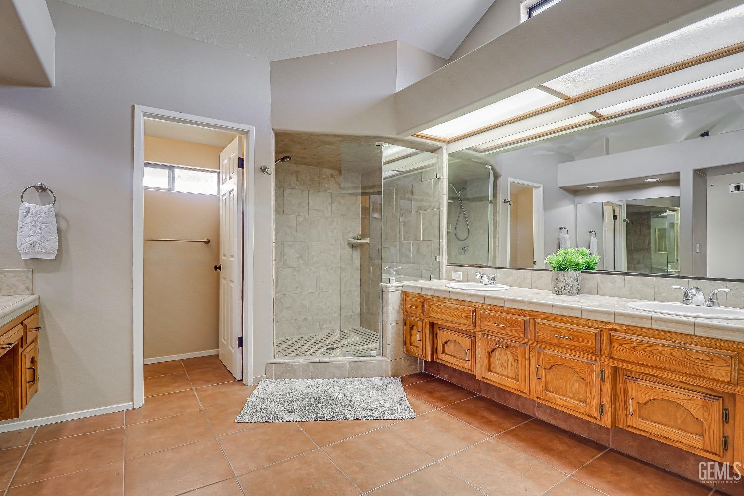 Undisclosed Address Bakersfield, CA 93311 - Photo 31 of 51 a spacious bathroom with a granite countertop sink mirror and a bath tub