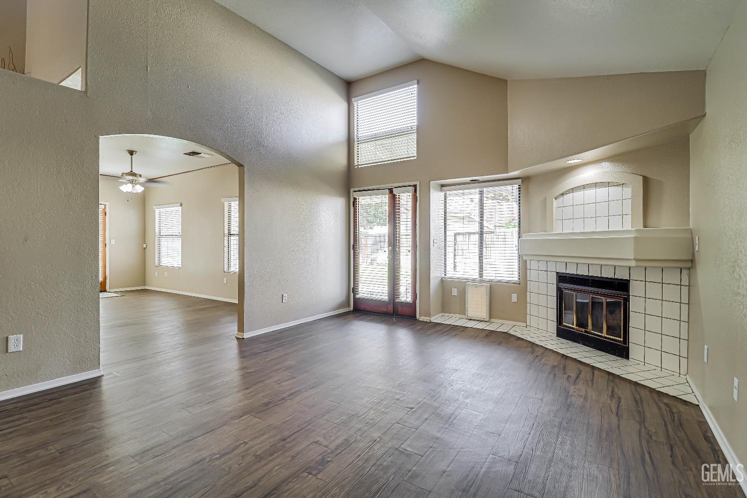 Undisclosed Address Bakersfield, CA 93311 - Photo 7 of 51 an empty room with wooden floor fireplace and windows
