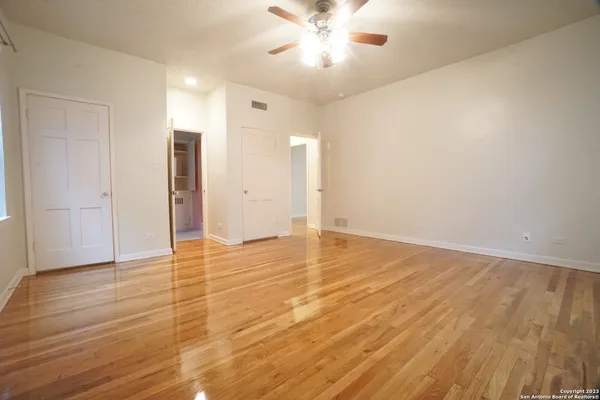 a view of an empty room with wooden floor