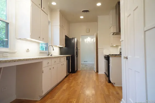 a kitchen with a refrigerator sink and cabinets