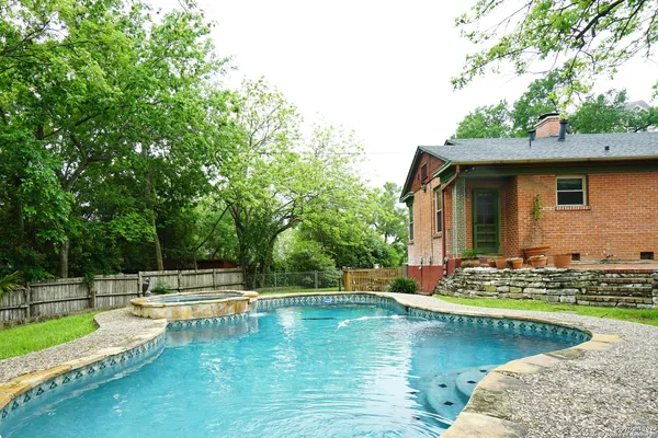 a view of a house with swimming pool and yard