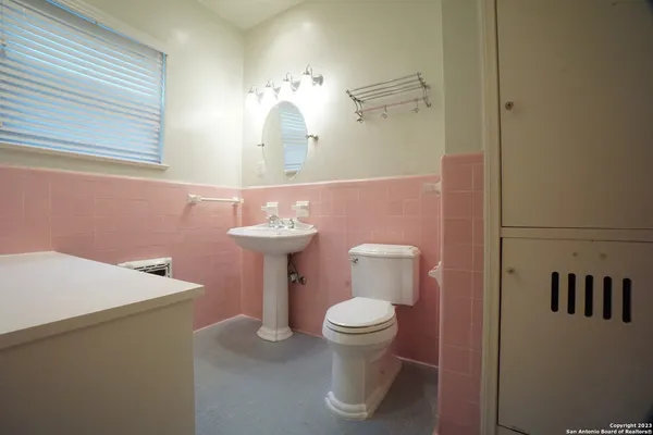a bathroom with a sink a toilet and mirror