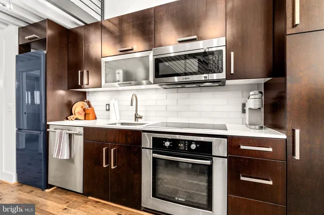 a kitchen with stainless steel appliances granite countertop a stove microwave and refrigerator