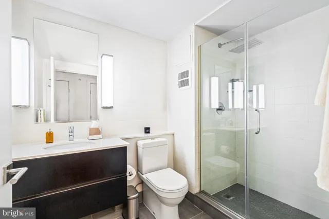 a bathroom with a sink toilet vanity and shower