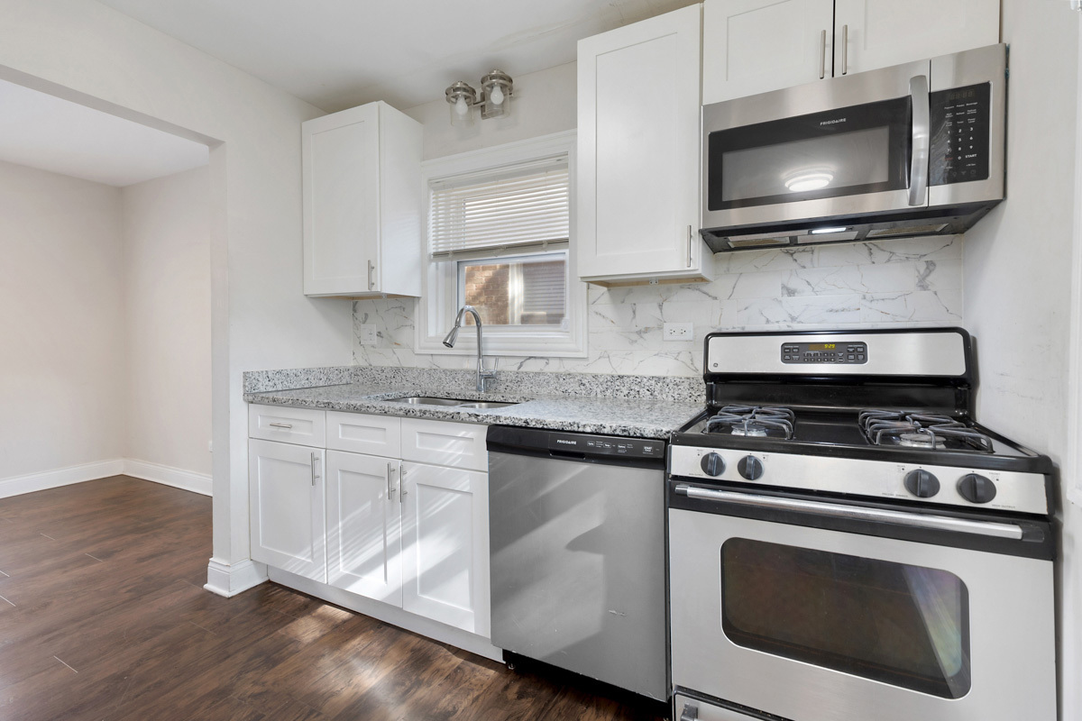 12511 South State Street Chicago, IL 60628 - Photo 11 of 26 a kitchen with stainless steel appliances granite countertop a stove and a microwave