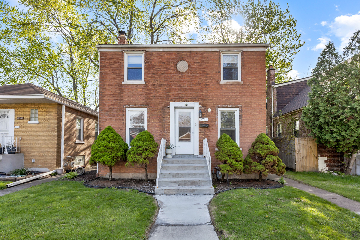 12511 South State Street Chicago, IL 60628 - Photo 2 of 26 front view of a house with a yard and an trees