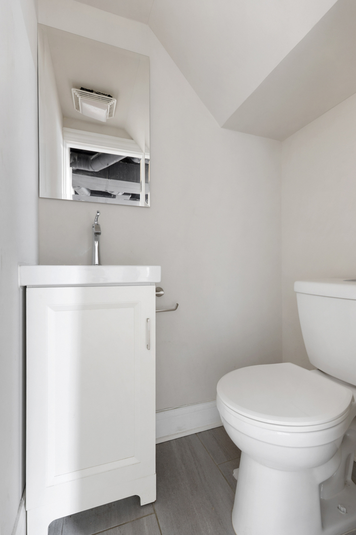 12511 South State Street Chicago, IL 60628 - Photo 21 of 26 a white toilet sitting next to a bathroom sink