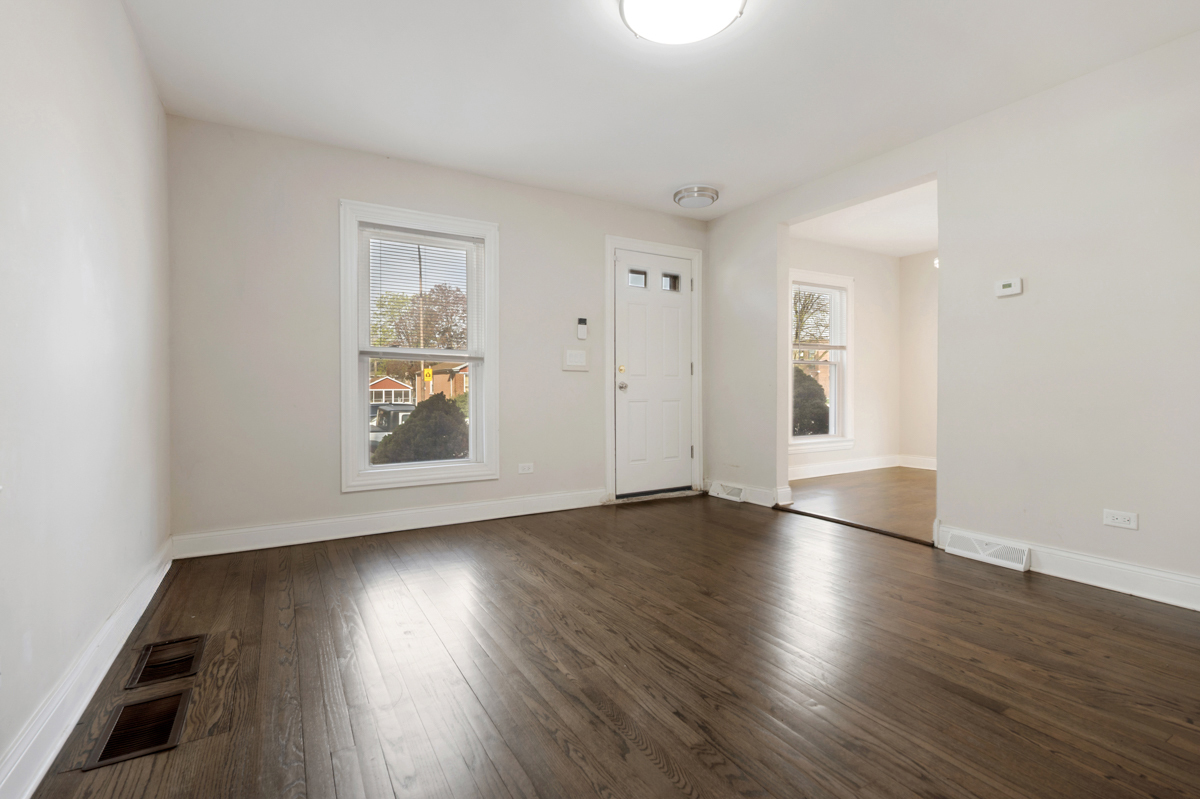 12511 South State Street Chicago, IL 60628 - Photo 4 of 26 an empty room with wooden floor and window