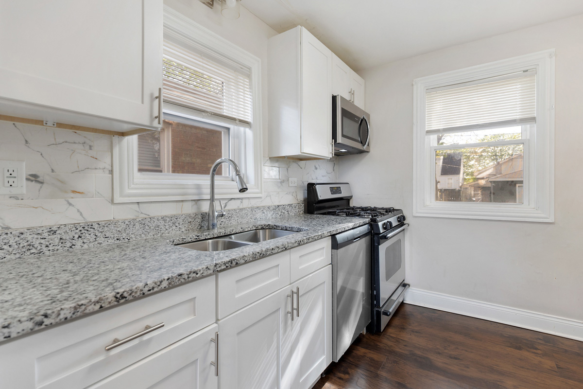 12511 South State Street Chicago, IL 60628 - Photo 10 of 26 a kitchen with stainless steel appliances granite countertop white cabinets granite counter tops and a window