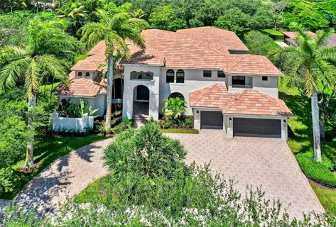 an aerial view of a house with yard and patio