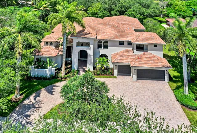 an aerial view of a house with yard and patio