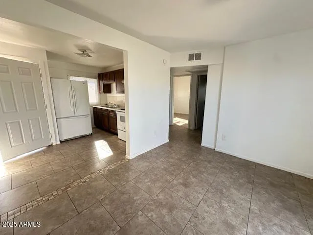 an empty room with a kitchen and a sink