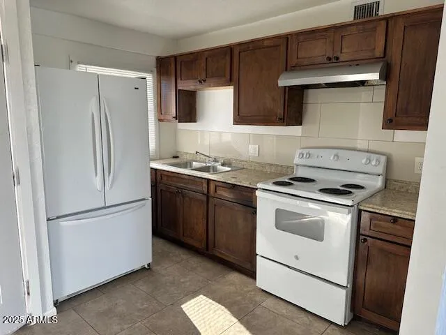 a kitchen with a stove sink and refrigerator