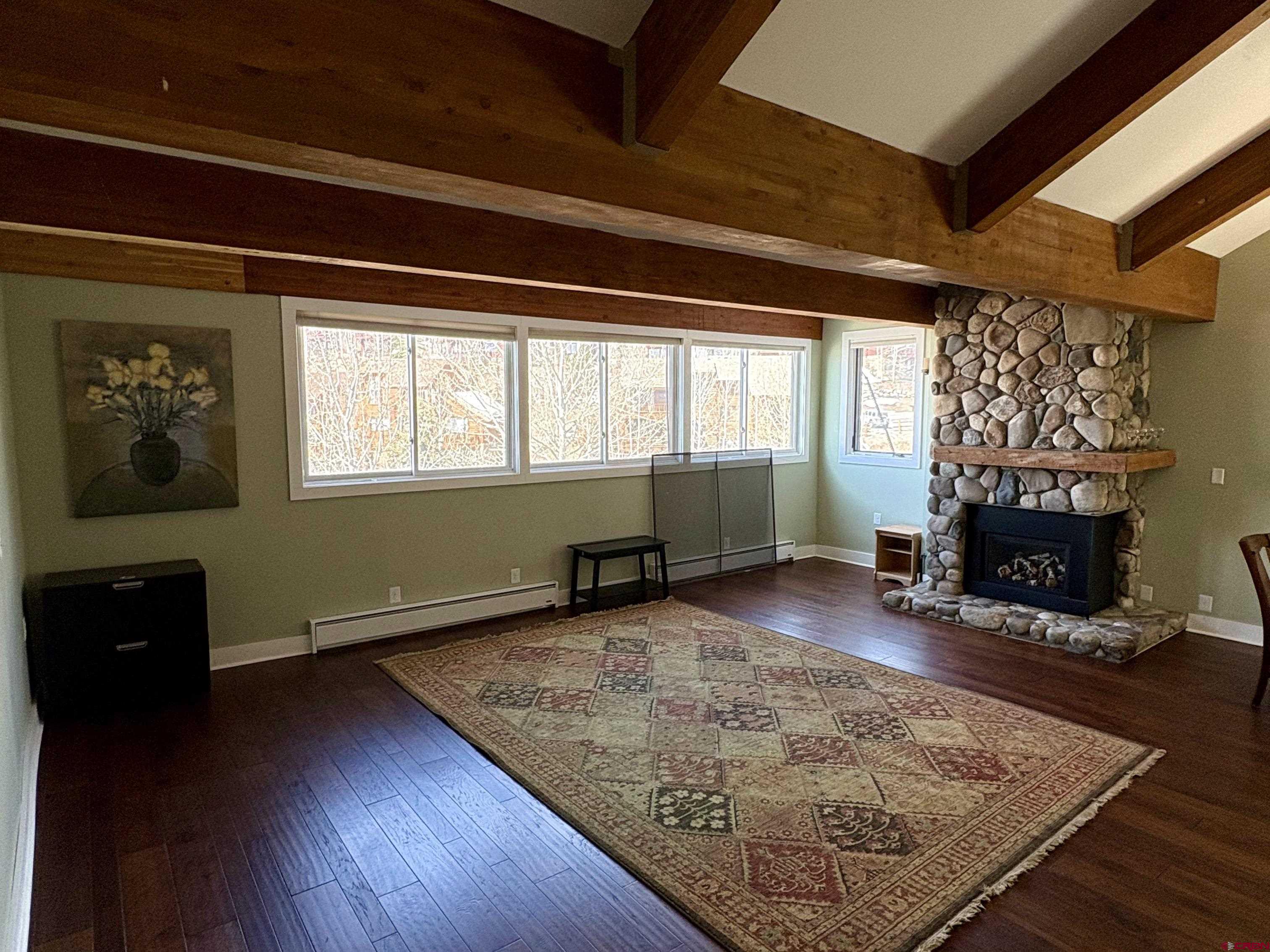 11 Hunter Hill Road, Unit 506 Crested Butte, CO 81225 - Photo 9 of 35 an empty room with wooden floor fireplace and windows