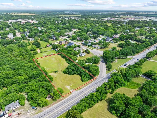 an aerial view of residential houses with outdoor space and trees