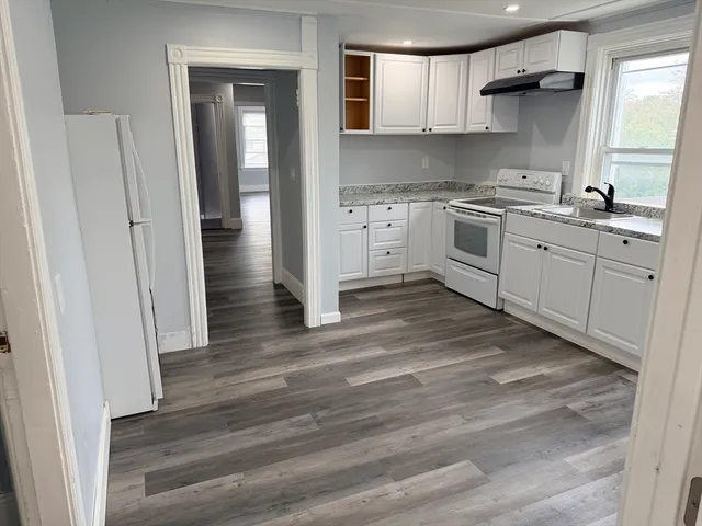 a kitchen with a sink cabinets stainless steel appliances and a window